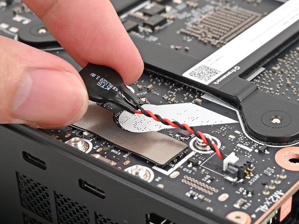 Orient the RTC battery so it's aligned with the white circular marking on the Mainboard.