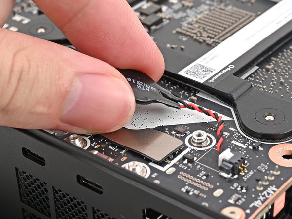 Press the RTC battery onto the Mainboard to secure the adhesive.