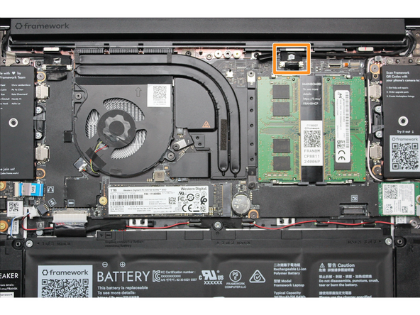 Using your fingers, carefully disconnect the Webcam cable on the top, right hand side by using the black pull tab to pull it directly upward.