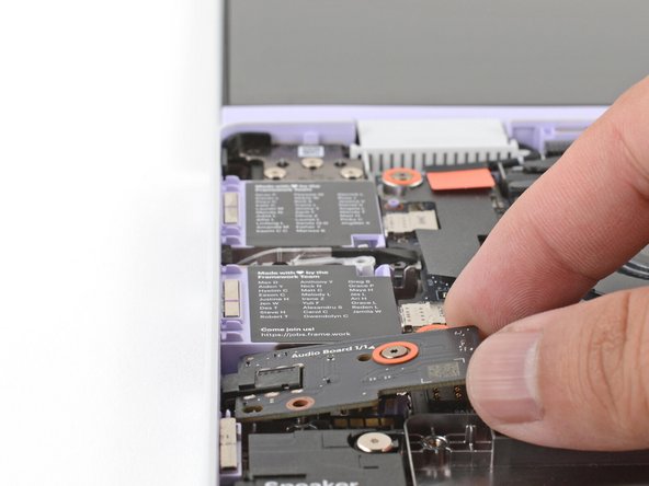 Use your fingers to lift the right edge of the Audio Board and pull it out of its recess.