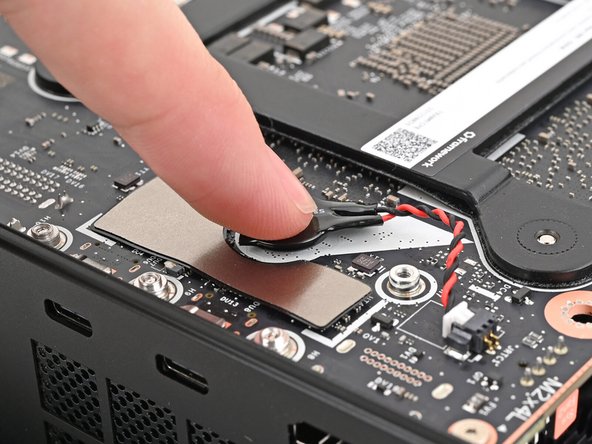 Press the RTC battery onto the Mainboard to secure the adhesive.