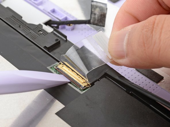 Use the flat end of your Framework Screwdriver to flip up the locking bar around the display connector.