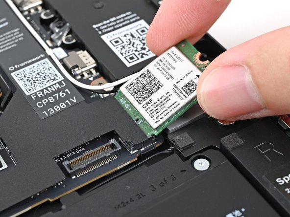 Grip the end of the Wi-Fi module with the screw hole and slide it out of its socket.