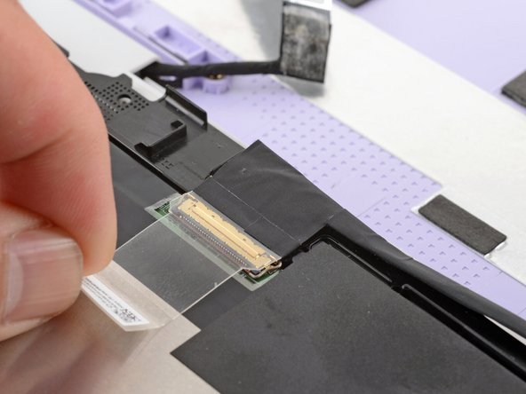 Use your fingers to peel up the clear tab covering the display cable connector.