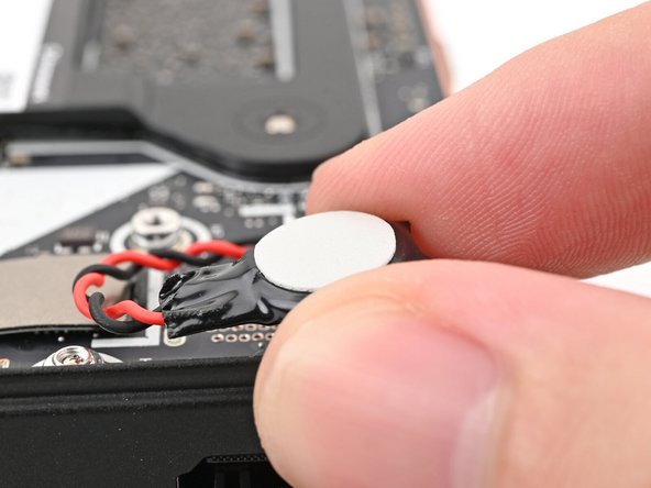 Peel the white liner off the back of the RTC battery to expose the adhesive.