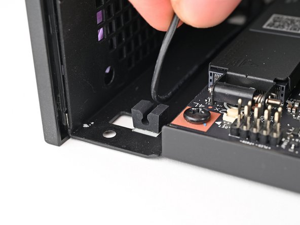 Pull the power button cable out of its rubber clips in the chassis.