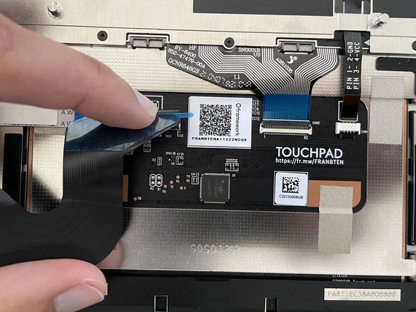 Lift up the Touchpad Cable carefully, and stick the piece of double sided tape onto the Touchpad cable in an area where it will only touch the metal bracket on the Touchpad when pressed back down.