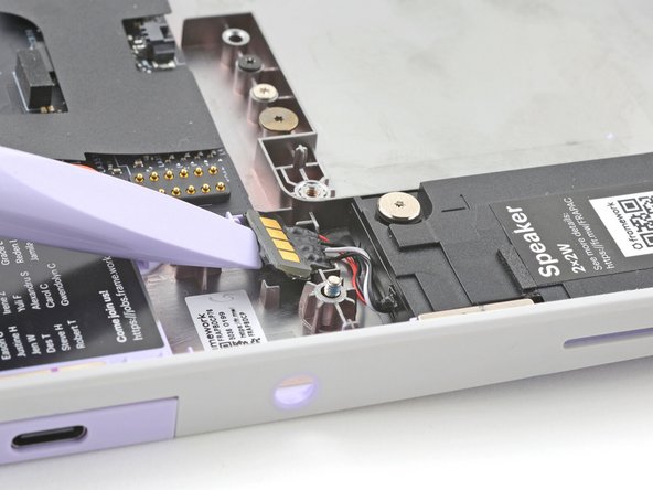 Use the flat end of your Framework Screwdriver to pry up the speaker connector from its recess near the top of the left speaker.