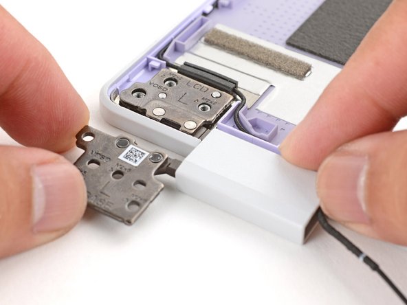 Lay both hinges in place in the Top Cover.