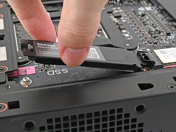 Insert the SSD into the socket at a shallow angle. The gold contacts should mostly be covered by the socket.