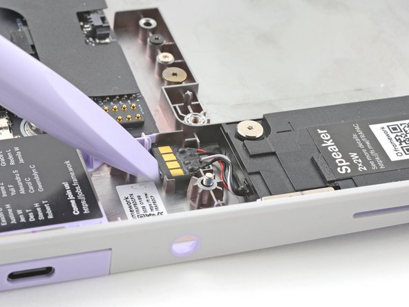 Use the flat end of your Framework Screwdriver to pry up the speaker connector from its recess near the top of the left speaker.