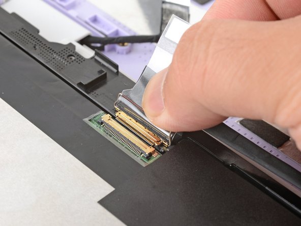 Grasp the display cable near the connector and slide it out of the connector.