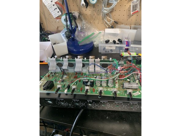 Press the wires from the output transformer as far away from the board and as close to the chassis as possible. The board needs to come down toward the bottom of the amp before the pots will clear the top of the chassis as shown.