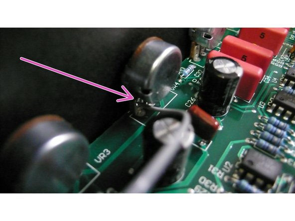At the bass pot there is a small hole right where the pink arrow  is pointing. Insert one end of the 10” wire into the hole and carefully  solder  it  in  place.
