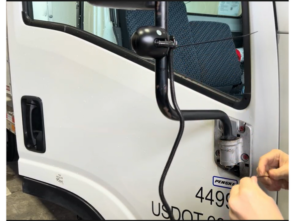 Slide the camera bracket clamp around the mirror arm (or pole mount) and position it at the desired height.