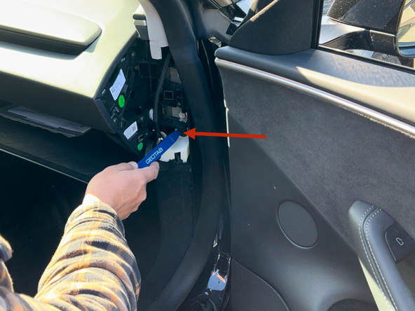 With a panel popper tool remove the clip as shown.