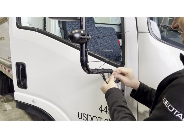Starting at the camera, run the coax cable down the length of the mirror arm toward the cab.