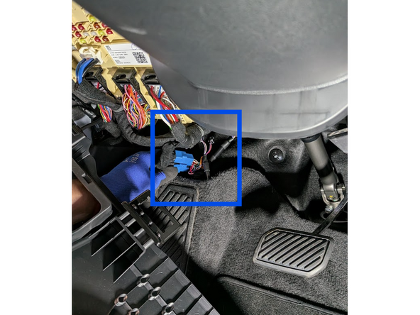 Carefully route the harnesses below the carpet to the cupholder area in the center console.