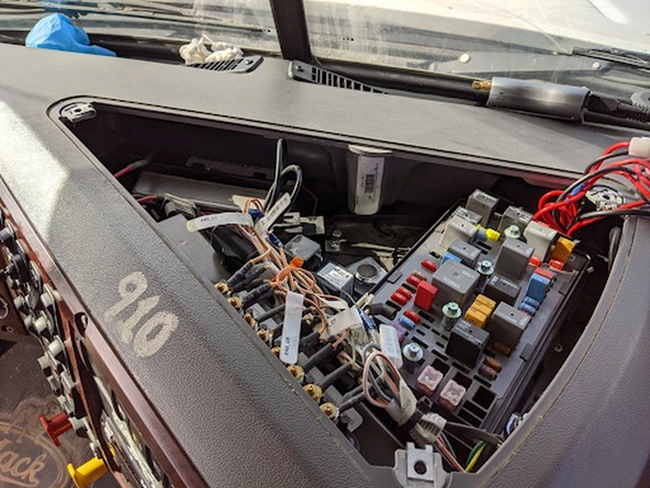 Remove the three T-25 screws holding the fuse box cover in place and then remove the cover.