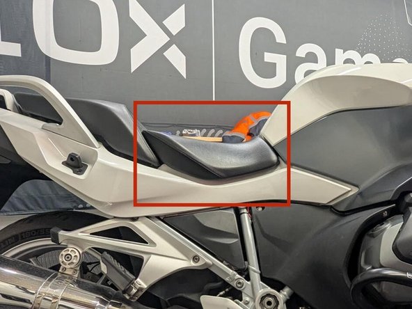 Unlock the seat by turning the ignition key clockwise and then slightly raise the seat at the back.