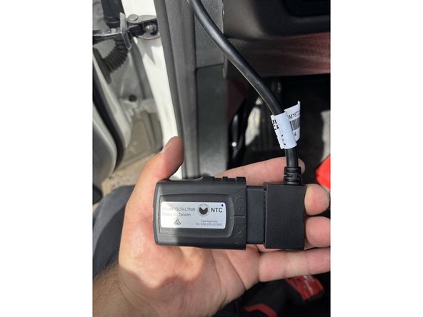Take the Geotab GO device (model GO-LTMB or applicable GO model) and connect it to the harness cable end.