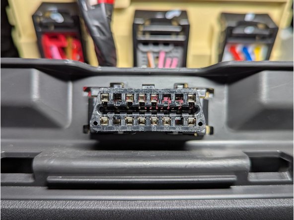 Carefully unclip the vehicle's diagnostic port and detach it from the plastic mounting bracket.