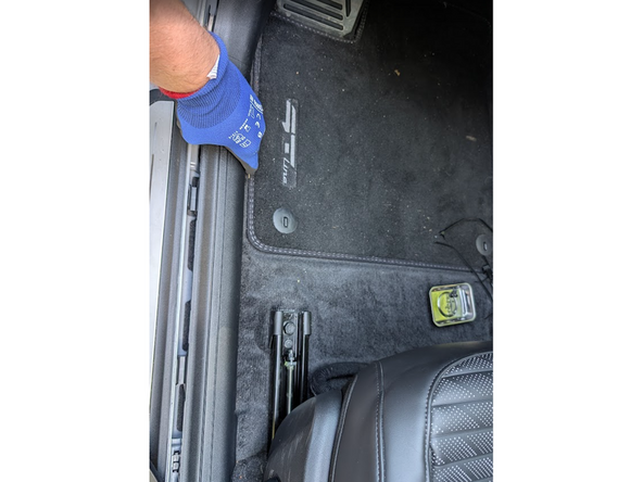 Unhook the plastic trim panel along the bottom door opening.