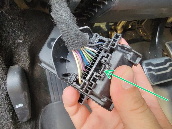 Once the Ford SDLM is free, unplug connector by pressing this tab and pulling out in the direction of the harness.