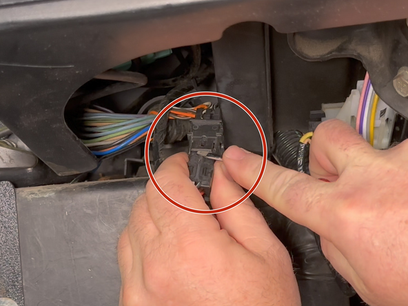Using a small flat blade screwdriver, pry up on the locking tabs to release the ECM connector.