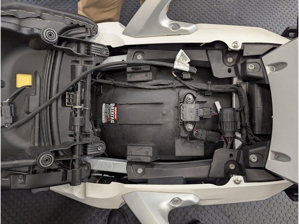 Pull the passenger seat slightly forward and lift the seat slightly.