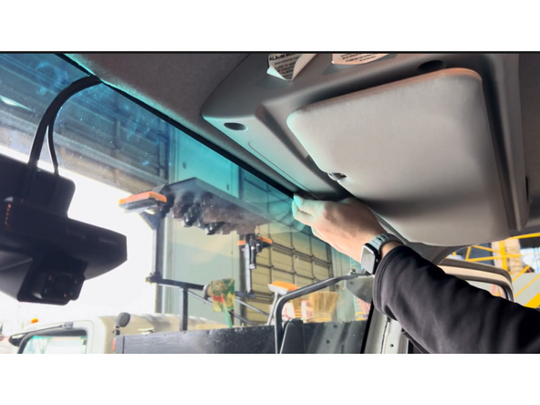 Tuck the harness cable behind the headliner toward the A-pillar, ensuring it is not obstructing the driver's view.