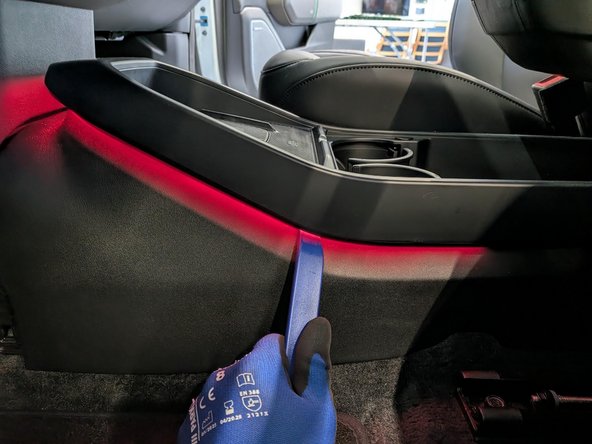 Use a trim-panel removal tool to detach the upper center-console cover.