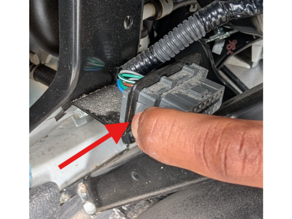 Release the OBD port from the mounting bracket by pressing in the side clips on the plastic connector.