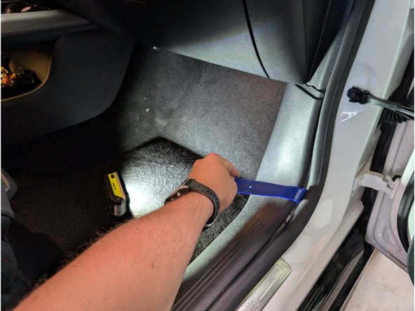 Unhook the plastic trim panel along the bottom door opening.