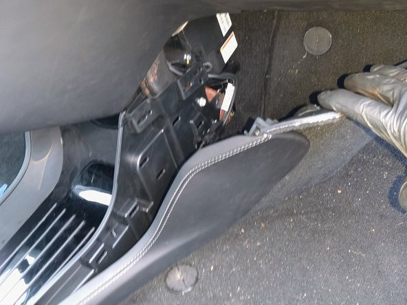 Unclip and remove the carpet and panel in the passenger footwell.