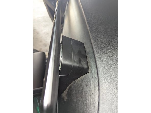 Just behind the infotainment display, remove the top cover using a flat-bladed screwdriver or plastic pry tool.