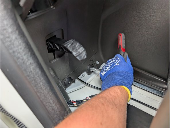 Remove the two remaining screws securing the panel. Then, use a panel removal tool to detach the panel.