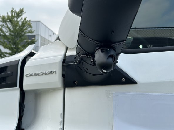 Using the large clamps, mount the auxiliary camera assembly to the large aero style mirror by routing the clamps around the mirror housing and tightening securely.