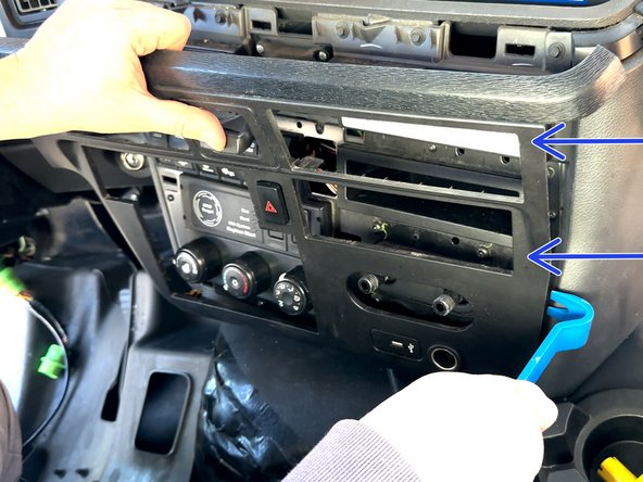 Using a panel removal tool, remove the center dash trim panel.