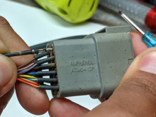 With the screwdriver provided, push down on each tab inside the Connector. This allows for the pin to unlock and slide out. Repeat this step for all the pins to completely de-pin the Connector