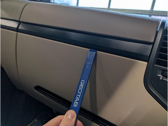 Use a panel-tool or similar tool to unclip and remove the cover-strip across the centre of the dashboard