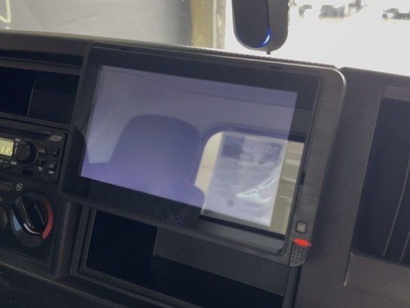 Carefully slide the monitor into the DIN bracket, engaging the ball-mount arm.