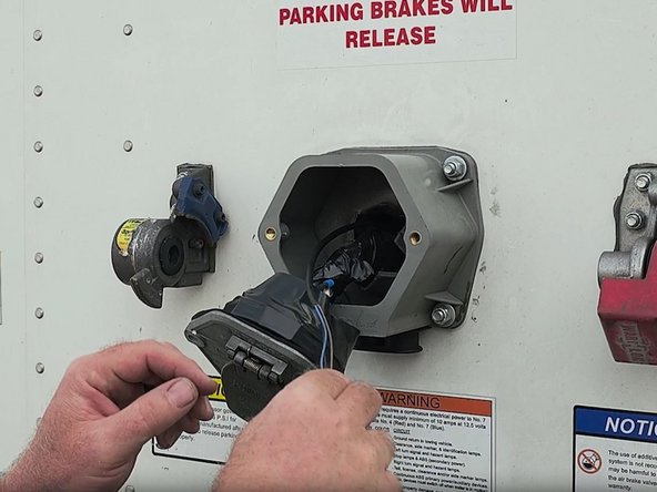 Once the panel has been removed, retrieve the harness from the wall cavity and then route the harness through the nose box passthrough.