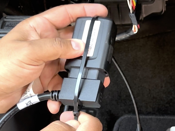Secure the device to the harness with the included cable tie.