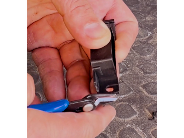 Begin by modifying the adapter, because the factory mounting location is too narrow for this installation. Cut off the right side of the adapter between the two holes, as shown in the image.