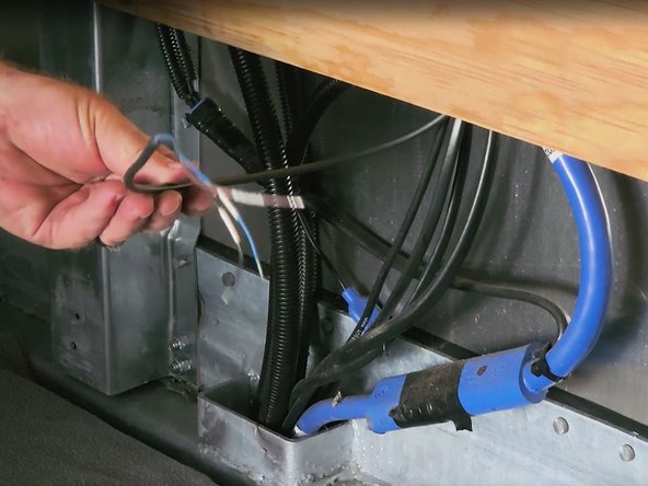 Once the panel has been removed, retrieve the harness from the wall cavity and then route the harness through the nose box passthrough.