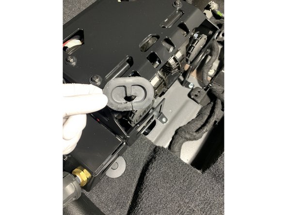 To seal the hole in the floor from the grommet removed earlier, cut a hole in the grommet for the wires to pass through and reinstall.