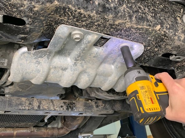 Using a 15mm wrench/socket, remove the two bolts holding the silver factory EPAS power steering skid plate to the front crossmember.