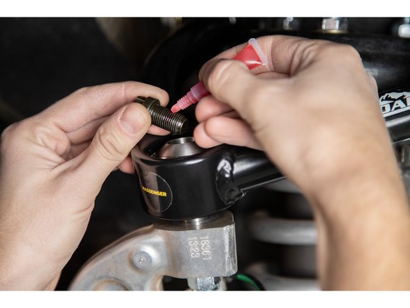 Remove the 1/2-20 12 point cap screws from the top of the uniballs.  Apply provided threadlocker to the threads, and re-install.