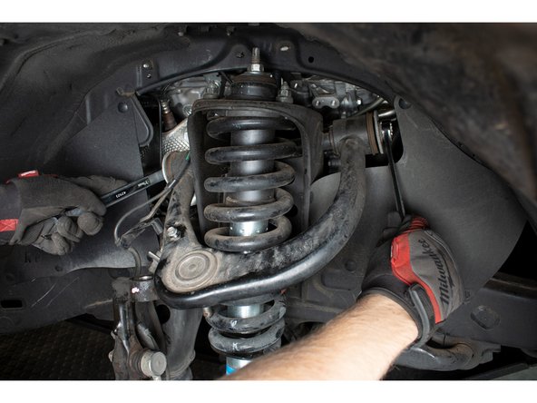 Using a 19mm socket and/or wrenches, remove the nut and washer from the rear side of the long pivot bolt. Carefully feed the bolt forward until it clears the front of the A-arm.